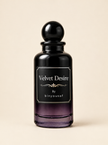 A dark glass perfume bottle with a black spherical cap and a black label reading 'Velvet Desire By binyousaf' on a warm beige background.